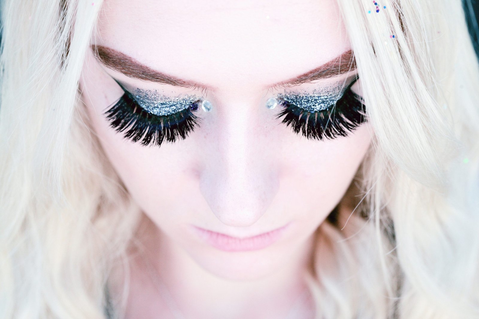 fashion - wordpressdiva - a close up portrait looking down on an 18 year old person wearing false eyelashes and glitter eye shadow stockpack unsplash scaled