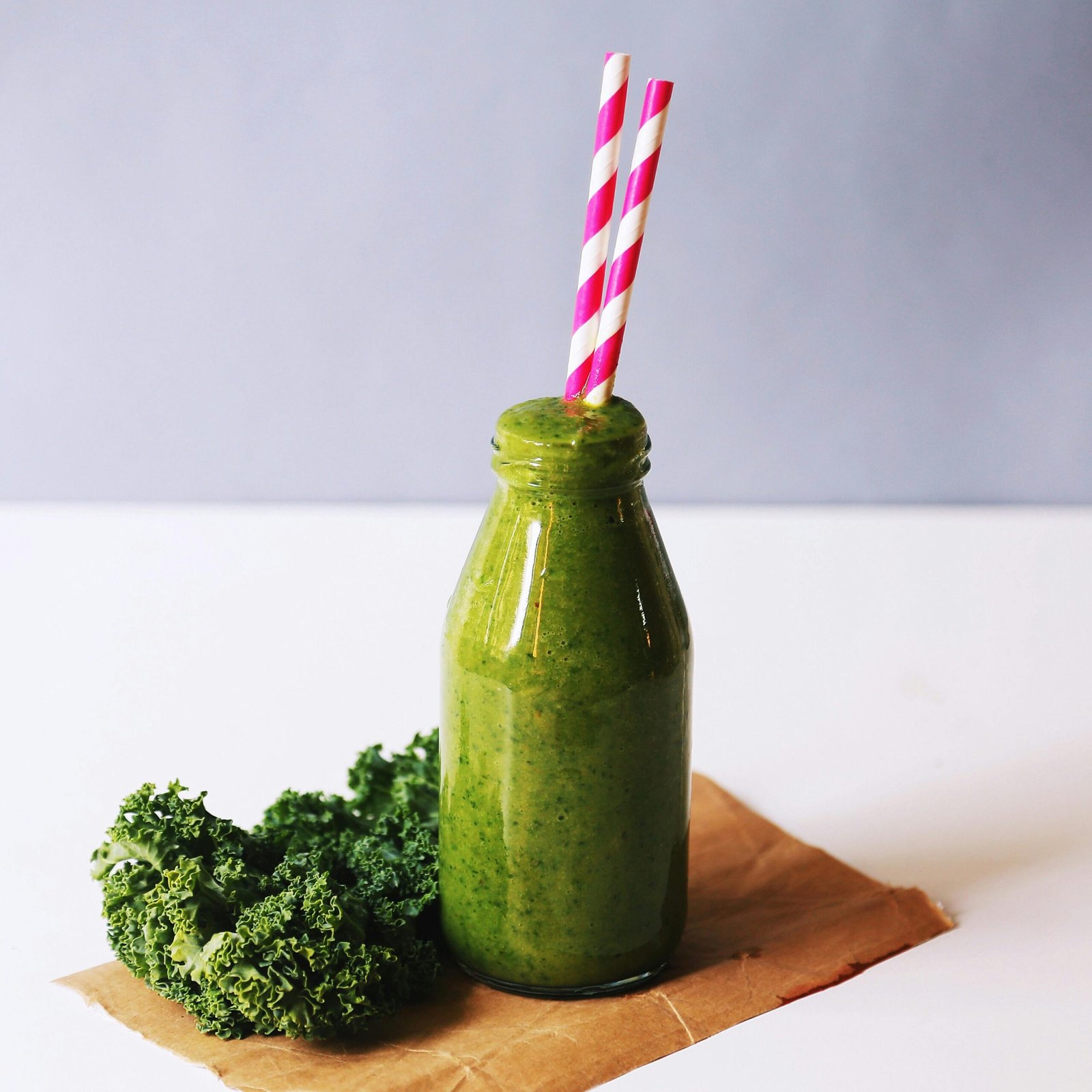 Clear glass bottle filled with broccoli shake