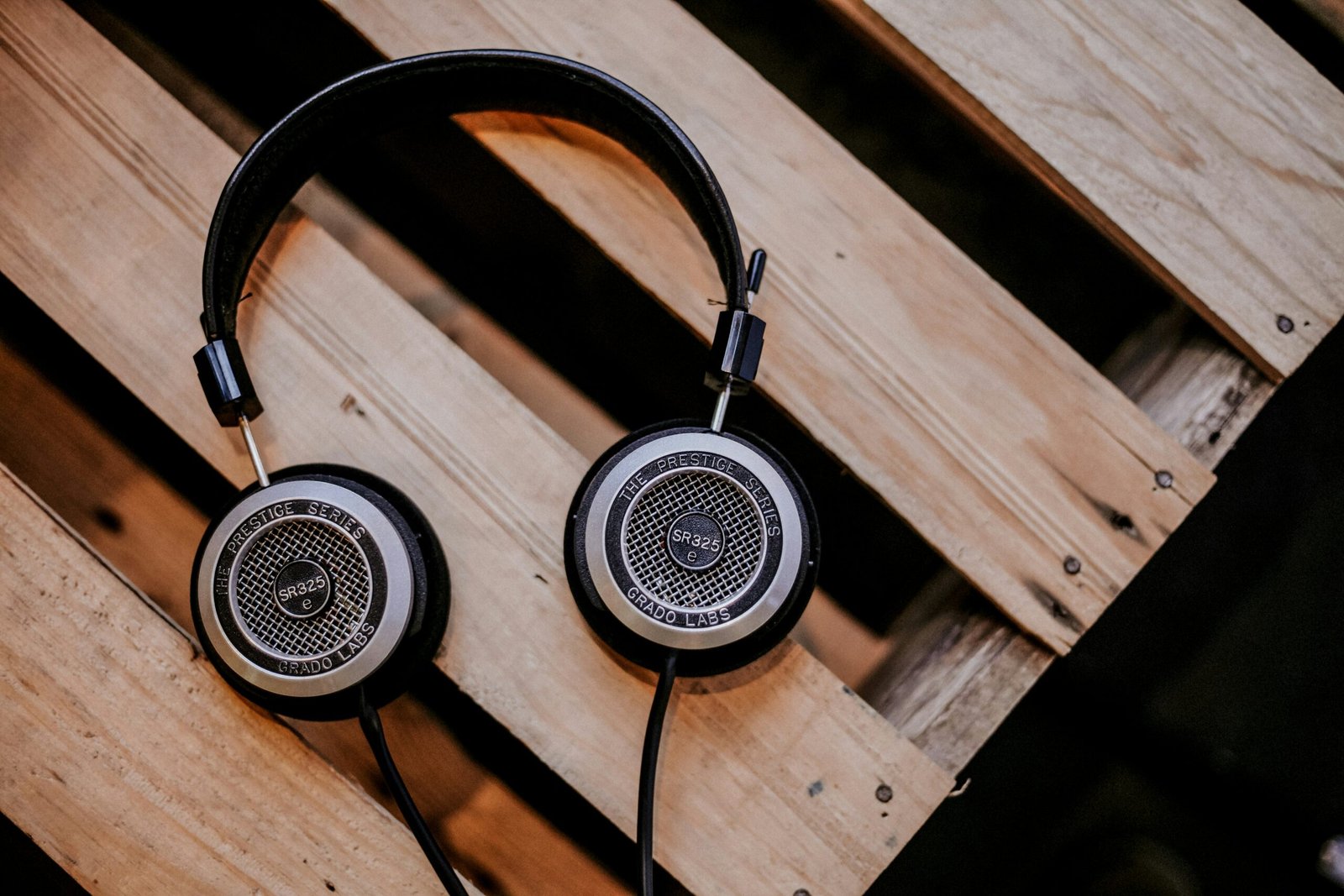 gray and black corded headphones on top of brown wooden surface