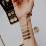 Swatches of eyeshadow testing on a woman's forearm