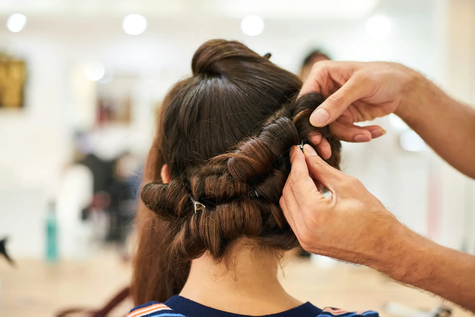 Woman hairdresser making hairstyle in beauty salon