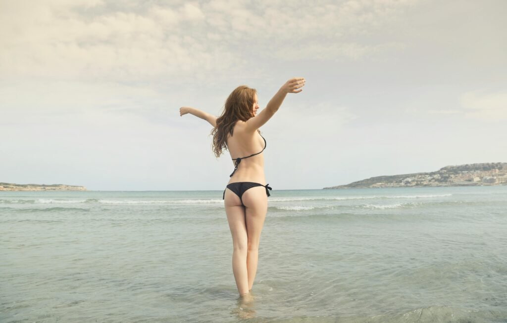 Woman in black bikini standing on shore