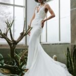 woman in white wedding dress standing beside green plant