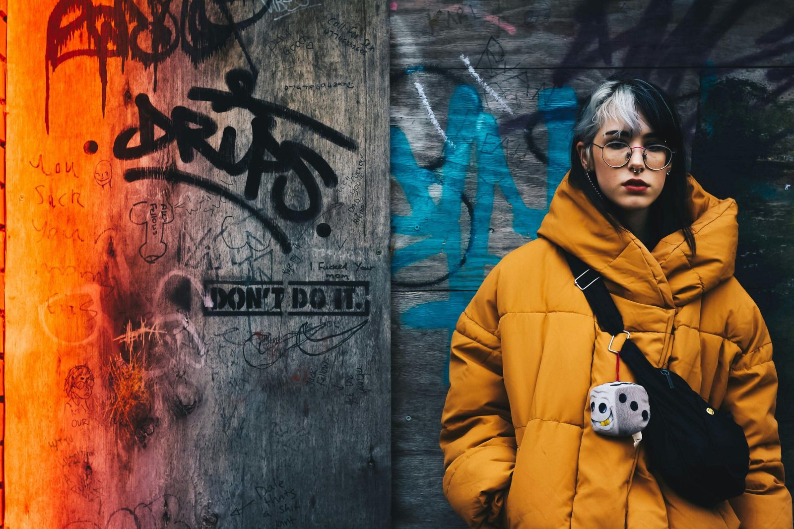 Woman in yellow coat with black crossbody bag closing her eyes