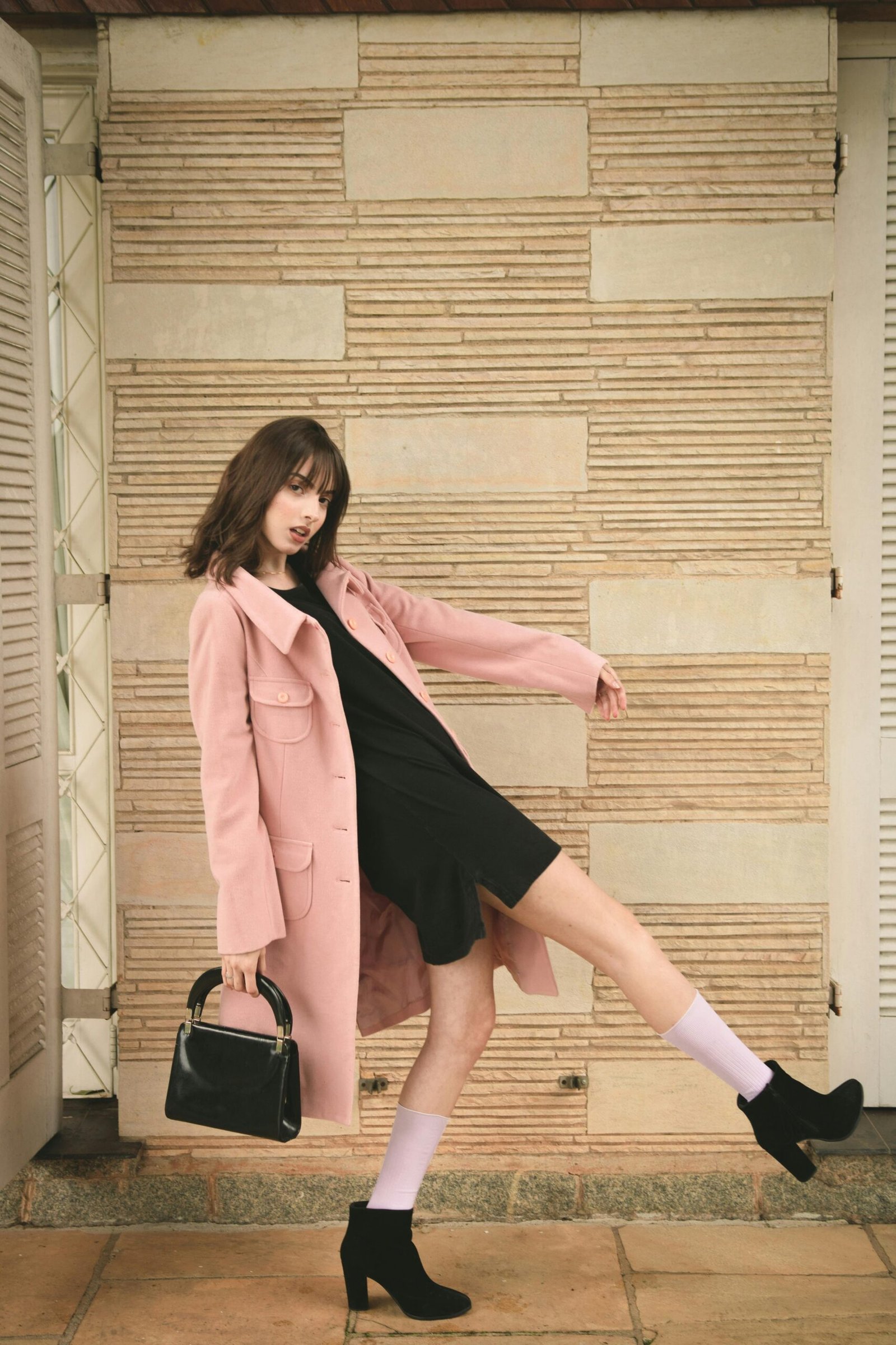 Woman wearing pink overcoat and black inner top