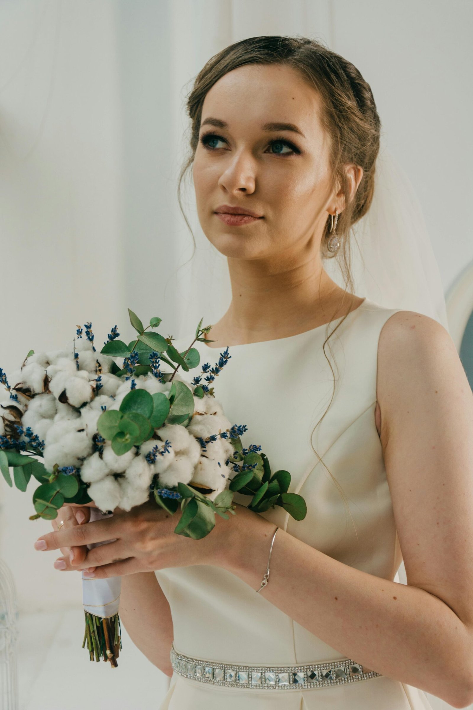 Woman wearing white gown holding bouquet of flowers