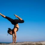 Woman with arms outstretched against blue sky