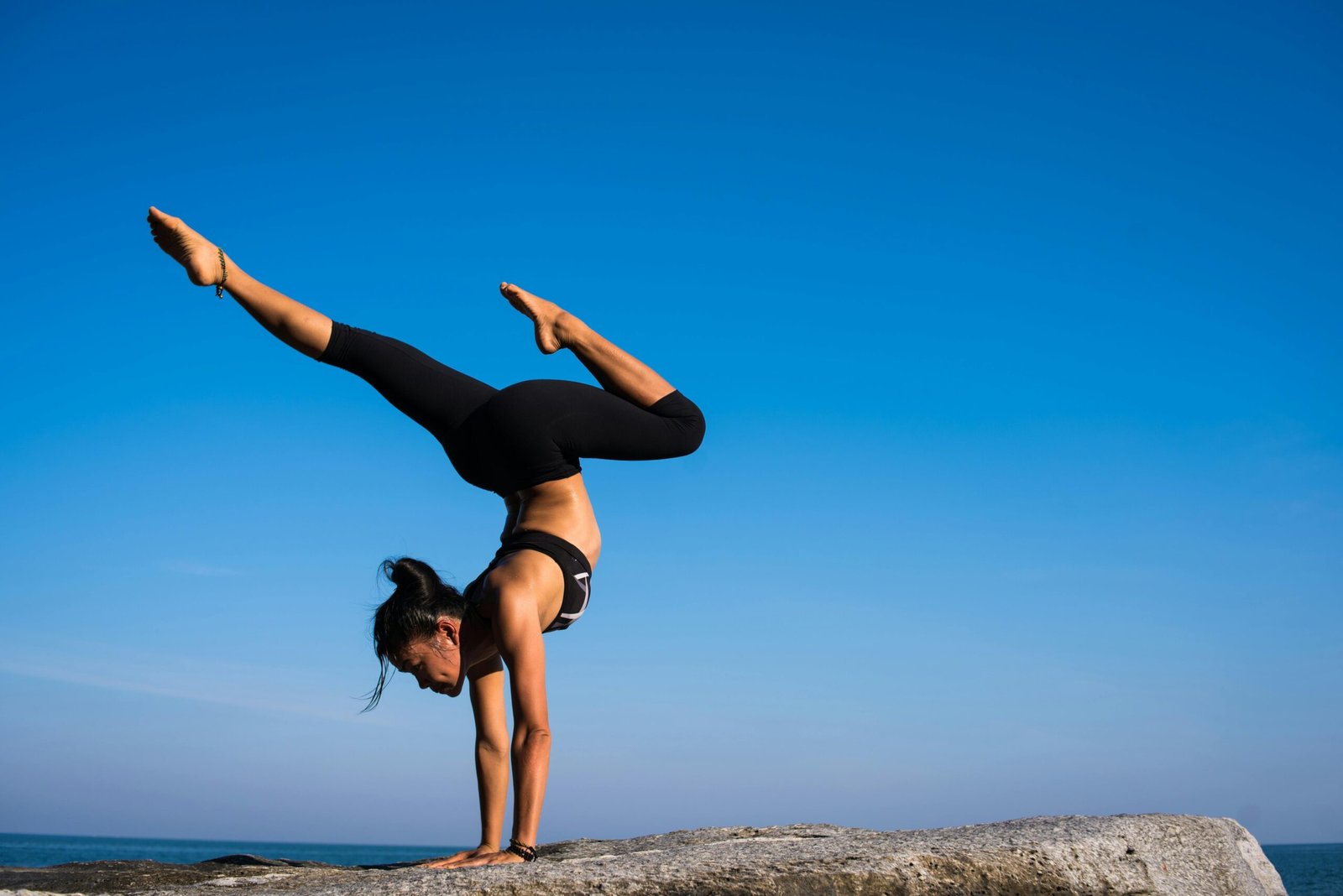 Woman with arms outstretched against blue sky